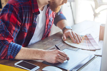 Male graphic designer working on digital tablet