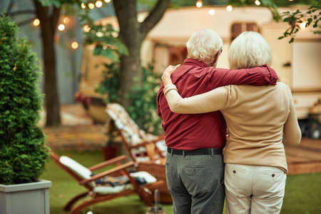 Senior spouses standing near their camper vanの写真素材