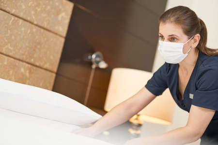 Experienced chambermaid in uniform doing room service in hotel