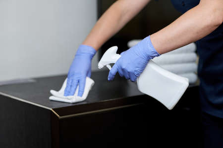 Maid doing disinfection of surfaces in the roomの写真素材