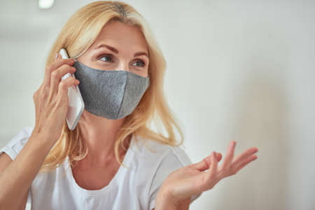 Middle aged caucasian woman talking on phone at homeの写真素材