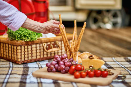 Food lying out on picnic blanket with basket on the backgroundの写真素材