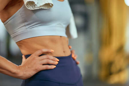 Ideal body. Cropped shot of fitness woman with perfect abs standing at gym, selective focusの写真素材