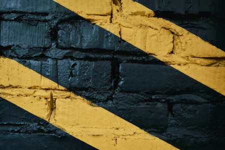 Black brick wall with yellow stripes at gymの写真素材