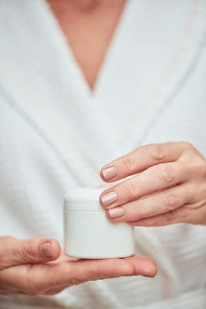 Cream bottle in manicured woman handsの写真素材