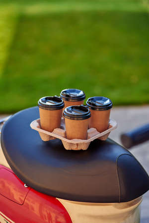 Four paper coffee cups standing on scooter, selective focusの写真素材