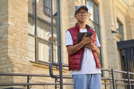 Tracking order. Young asian male courier using app on digital ta