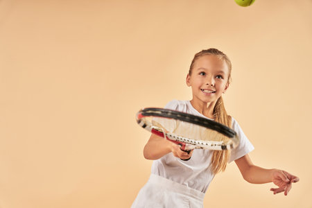 Cute female child playing tennis and smilingの写真素材