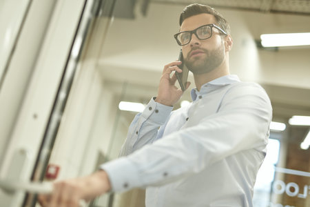 Calm man talking on the phone while entering the room