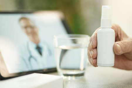 Person holding a generic spray bottle with medicationの写真素材