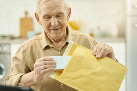 Elderly citizen unpacking his medicine mail orderの写真素材