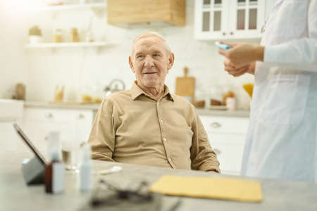 Senior citizen having doctor visit him at home