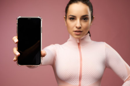 Attractive young woman holding smartphone with black displayの写真素材