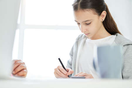 Diligent student. Focused teenage latin girl drawing something while spending time with her father...