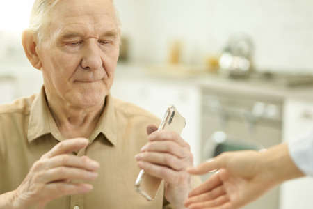Senior man using smartphone while staying home