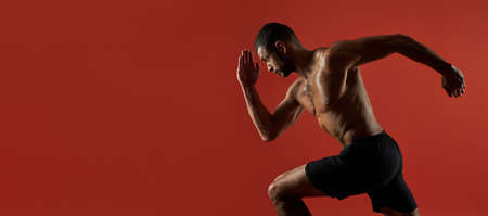 Website header of Strong athlete with powerful torso in action isolated on red background of a studioの写真素材