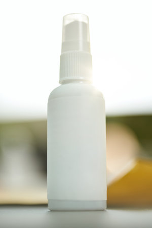 Handy travel-size bottle of sanitizer on the tableの写真素材