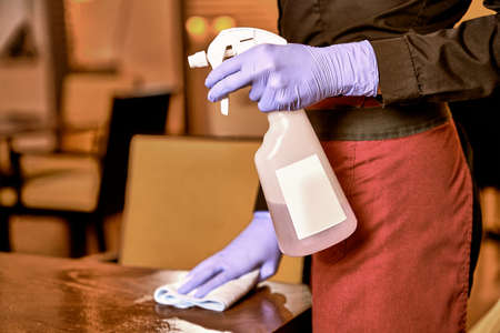 Server with wiping cloth cleaning a restaurant tableの写真素材
