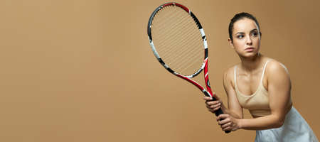 Website header of Pretty woman with tennis racket standing against yellow backgroundの写真素材