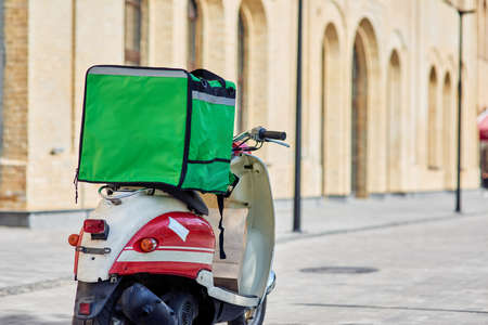 Fresh food from restaurant to your door. Green delivery thermo backpack on scooter