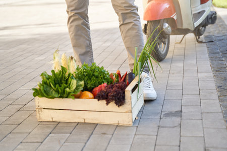 Wooden grocery box with fresh vegetables standing on the streetの写真素材