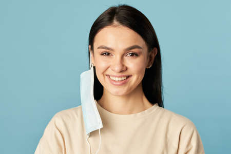 Happy female posing in a disposable protective mask from viruses