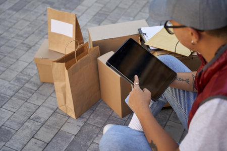 Male courier looking at map or using app on digital tablet whileの写真素材