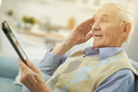 Elderly man consulting online with a therapist at home