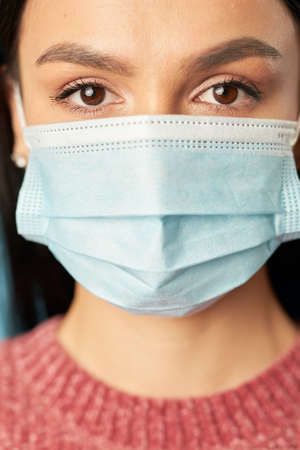 Beautiful woman posing in a disposable protective mask from virusesの写真素材