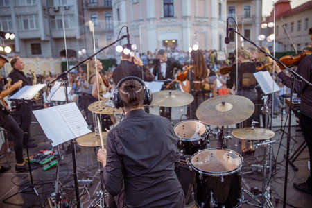 Male musician playing drums at orchestral concert outdoorsの写真素材