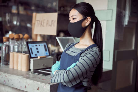 Young waitress waiting for clients inside coffee shopの写真素材