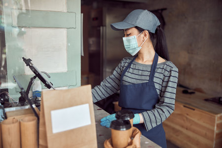 Female employer checking order near cafe counterの写真素材