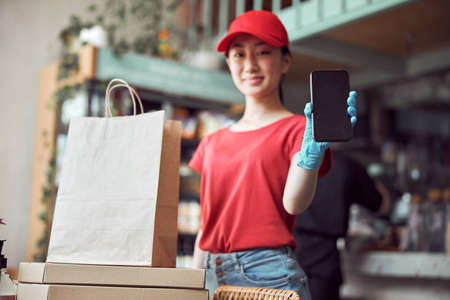 Female cafe worker taking online orders indoors