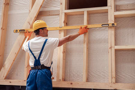 Male builder in safety helmet working at construction site