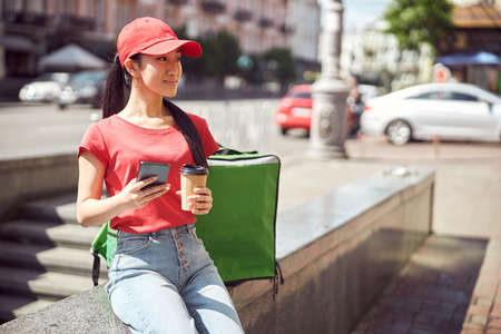 Woman courier worker enjoying free time outdoorsの写真素材