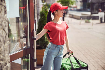 Young woman courier working with online orders outdoors