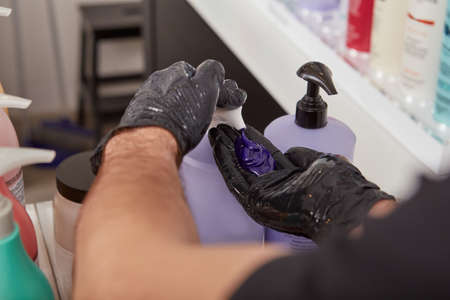 Hairdresser pumping out blonde purple shampoo from bottle