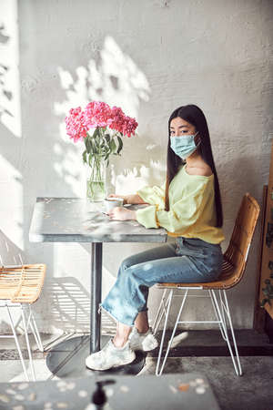 Young female feeling happy and fresh while sitting in cafeの写真素材