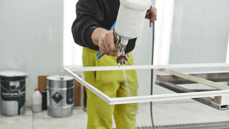 Bringing innovation to the surface. Man is holding airbrush spray vaporizer for painting and dyeing