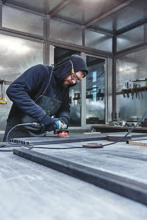 Loud and Fast. Mechanic steel. Grinding. Man holding hand grinder.の写真素材