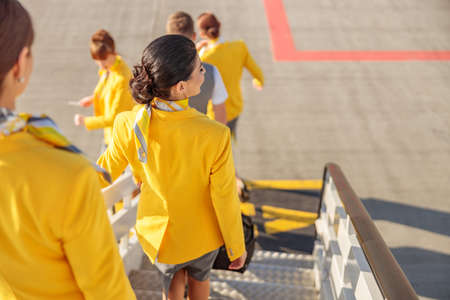 Female flight attendants walking down airplane boarding stairsの写真素材