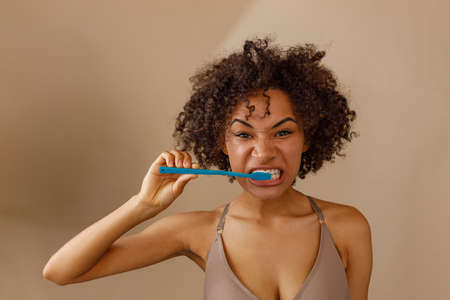 Young woman holding tooth blue brush in studioの写真素材
