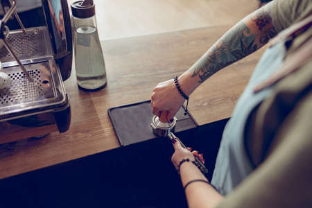 Young woman hands making coffee in cafeteriaの写真素材