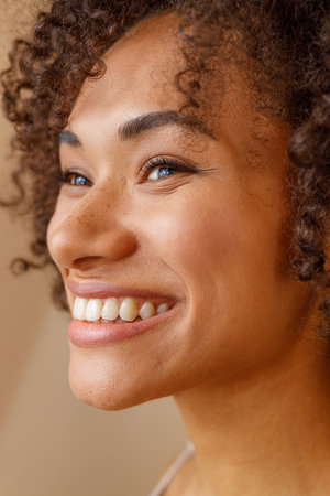 Multiethnic woman toothy smiling on beige background of studio