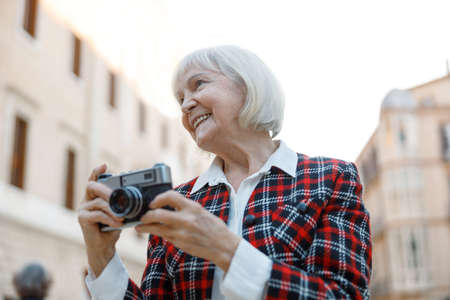 Elegant pensioner female walking on city streetの写真素材
