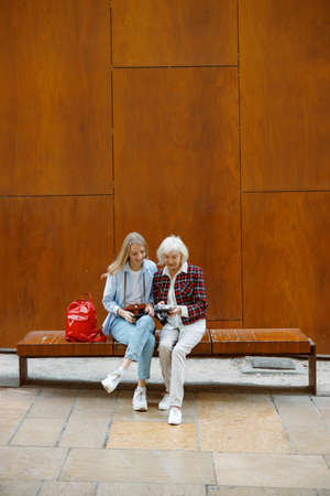 Happy elderly woman spending time with young lady outdoorsの写真素材