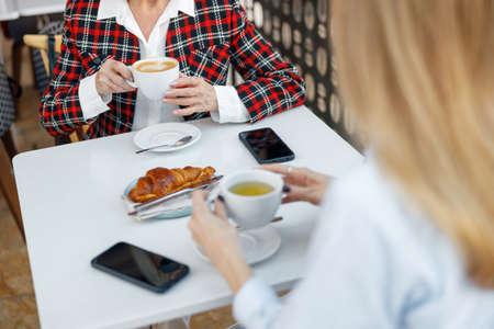Elderly woman having cup of coffee in cafeの写真素材