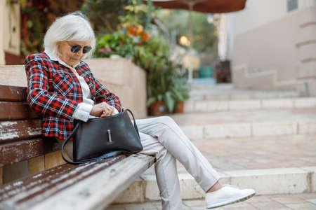 Senior lady resting on street of old townの写真素材