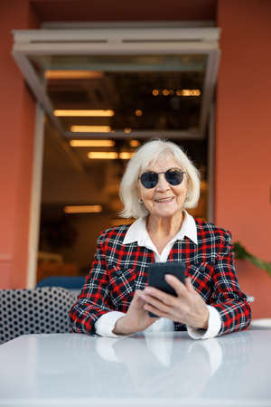 Portrait of confident senior woman sitting at urban cafeの写真素材