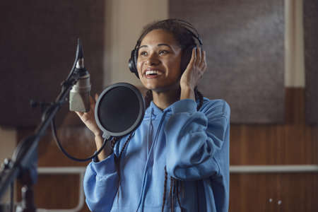 Female singer records new song. Emotional actress voices text, rehearses with enjoyment and emotions...